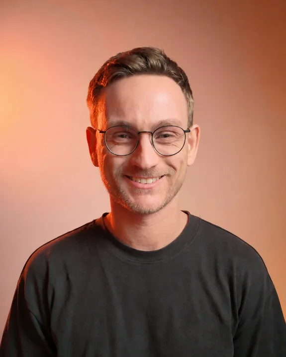 Elliot Matthews, founder of E Labs, smiling in a studio portrait